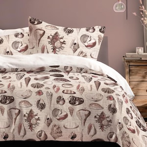 May include: A bed with a seashell-patterned duvet cover and pillowcases. The design features various seashell illustrations in shades of brown and cream. The bed is made up with white sheets.