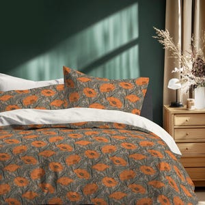 May include: Bedding set featuring a duvet cover and pillowcases with a repeating pattern of orange poppies on a gray background. The bed is made with white sheets and is set against a dark green wall.