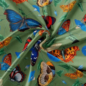 May include: Green fabric with a repeating pattern of colourful butterflies. The butterflies are in various poses and have different wing patterns. Some butterflies have brown, orange, blue, and black wings. The fabric has a green background with a floral pattern.