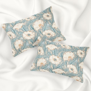 May include: Two decorative throw pillows with a floral pattern. The pillows feature a light blue background with white and orange poppy flowers.