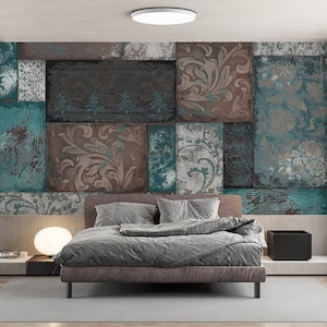 Puede incluir: Una cama tapizada en gris con cabecero y piecero, situada en una habitación con papel tapiz estampado que presenta un mosaico de azulejos de color turquesa, marrón y gris. El papel tapiz tiene un aspecto vintage y desgastado.