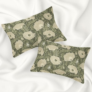 May include: Two green pillowcases with a floral pattern of white poppies on a white background.