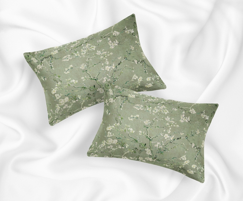 May include: Two green pillowcases with a white floral pattern. The pillowcases are made of a soft, comfortable fabric and feature a delicate floral design.
