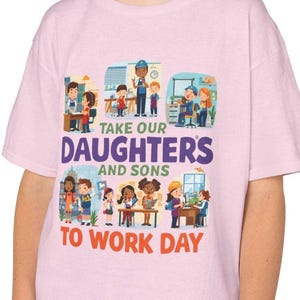 May include: A light pink t-shirt with the text "Take Our Daughters and Sons to Work Day" in white and red. The shirt features illustrations of children and adults in various work settings, including an office and construction site.