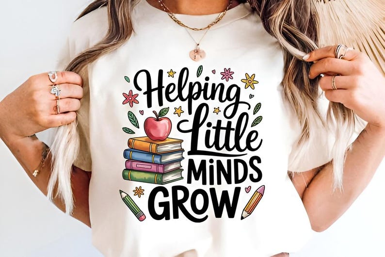 May include: Cream-colored t-shirt featuring the text "Helping Little Minds Grow" in black script. The design includes a stack of books, a red apple, pencils, and floral accents in various colors. A teacher-themed graphic.
