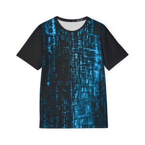May include: A short-sleeve t-shirt featuring a black and blue digital matrix pattern across the front panel. The design consists of glowing light blue binary code and abstract data streams set against a dark background, with solid black sleeves.