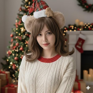 Peut inclure: Une femme portant un serre-tête sur le thème de Noël avec des oreilles d'ours, un chapeau à carreaux et un accent de bonhomme en pain d'épices. Elle porte un pull en tricot torsadé crème avec un col rouge. Un sapin de Noël et une cheminée sont en arrière-plan.