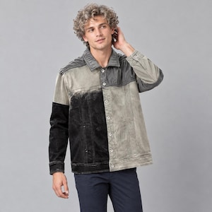 May include: A long-sleeve button-down jacket featuring a colour-blocked design with a solid black panel on the left side and a faded, distressed grey panel on the right side. The jacket includes a pointed collar, metal buttons, and pleated shoulders.