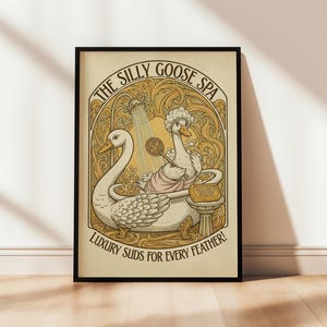Può includere: Stampa artistica incorniciata con un'illustrazione stravagante di due oche in un ambiente termale. L'opera d'arte include il testo "The Silly Goose Spa" e "Luxury Suds for Every Feather!" in stile vintage con toni oro e crema.