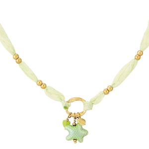 Könnte beinhalten: Zarte Halskette mit hellgrüner Bandkette und goldfarbenen Perlen. Ein goldfarbener Ringanhänger hält einen grünen Seestern-Anhänger, ein kleines grünes Herz und einen goldenen Muschel-Anhänger. Feminines Design.