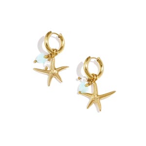 May include: Gold-tone hoop earrings with starfish charms, small blue beads, and tiny gold beads. The earrings have a nautical theme, perfect for beach lovers. The earrings are on a white background.