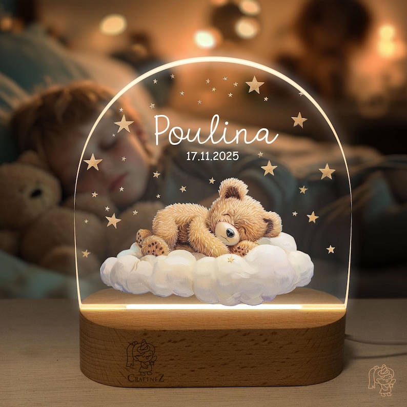 A glass lamp with a teddy bear on a cloud, surrounded by stars, and the name "Poulina" written on it.