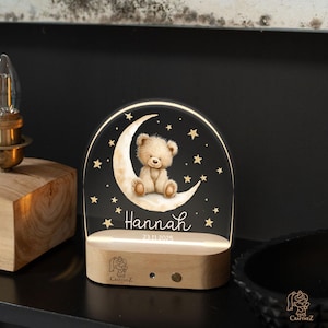 A wooden nightstand with a teddy bear on a crescent moon and stars, and the name "Hannah" written below.
