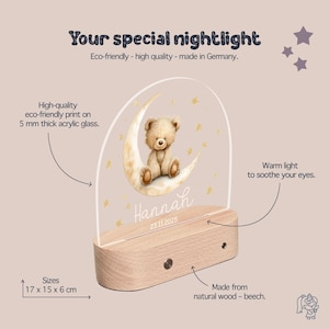 The image is a product description for a teddy bear-themed nightlight. It features a wooden base, a clear acrylic glass dome, and a crescent moon with a teddy bear on it. The nightlight is described as eco-friendly, high-quality, and made in Germany. The product is designed to provide a warm light to soothe eyes, and it is available in sizes of 17 x 15 x 6 cm. The nightlight is made from natural wood and beech.