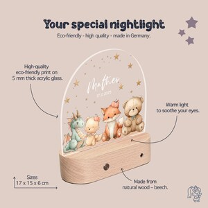 The image is a product description for a wooden nightlight featuring a clear acrylic glass dome with illustrations of a dragon, a bear, and a rabbit. The nightlight is described as eco-friendly, high-quality, and made in Germany. It is designed to provide a warm light to soothe eyes, and it comes in various sizes, including 17 x 15 x 6 cm. The nightlight is made from natural wood and beech.