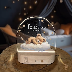 A wooden nightstand with a clear glass display case on top, featuring a teddy bear sleeping on a cloud and the name "Poulina" written on the display.