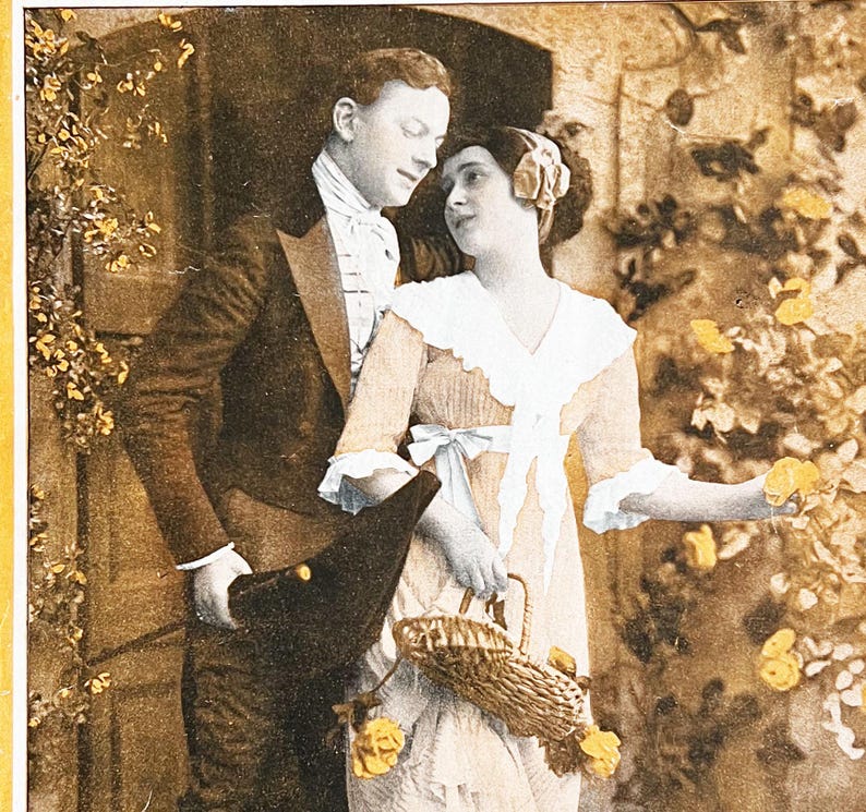May include: A sepia-toned photograph of a couple standing near a doorway. The man is wearing a suit and a hat, and the woman is wearing a dress with a lace collar and a basket. They are both looking at each other.