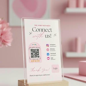 Könnte beinhalten: Ein klarer Acrylständer mit dem Text "Connect with us!" und Social-Media-Symbolen. Der Ständer steht in einem Holzsockel. Der Ständer enthält auch einen QR-Code und den Text "Thank You!" und "Thanks for supporting our small business!"