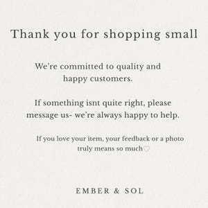 May include: A cream-colored card with black text that reads "Thank you for shopping small." Additional text includes a commitment to quality and customer satisfaction, and a request for feedback. The brand name "EMBER & SOL" is at the bottom.