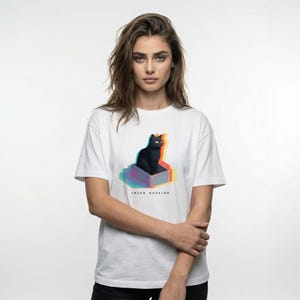 Puede incluir: Camiseta blanca con un dise&ntilde;o gr&aacute;fico de un gato negro en una caja con un efecto 3D colorido. El texto "think outside" est&aacute; impreso debajo. Un estilo casual y unisex.