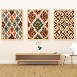 Peut inclure: Trois œuvres d'art murales encadrées avec des motifs géométriques colorés dans des tons orange, sarcelle, marron et crème. L'œuvre est exposée au-dessus d'une console en bois et d'une chaise blanche.
