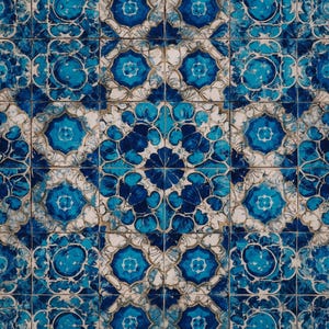 May include: A close-up view of a tiled surface with a repeating pattern. The tiles feature a design in shades of blue and white, with a central floral motif surrounded by geometric shapes. The overall effect is a decorative and intricate pattern.