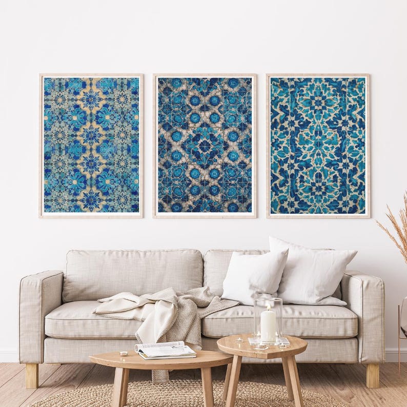 May include: Three framed wall art prints with intricate blue and white floral patterns. The prints are displayed above a beige sofa with white pillows and wooden side tables. The artwork adds a touch of elegance to the living room.