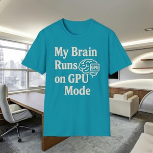 May include: A turquoise t-shirt featuring the white text "My Brain Runs on GPU Mode". The design includes a brain graphic with a GPU symbol. The shirt is shown in a modern office environment.