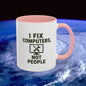 Puede incluir: Taza de cerámica blanca con interior y asa rosa. La taza presenta el texto "I FIX COMPUTERS, NOT PEOPLE" en negro, junto con un gráfico de un monitor de ordenador con una llave inglesa y un destornillador.