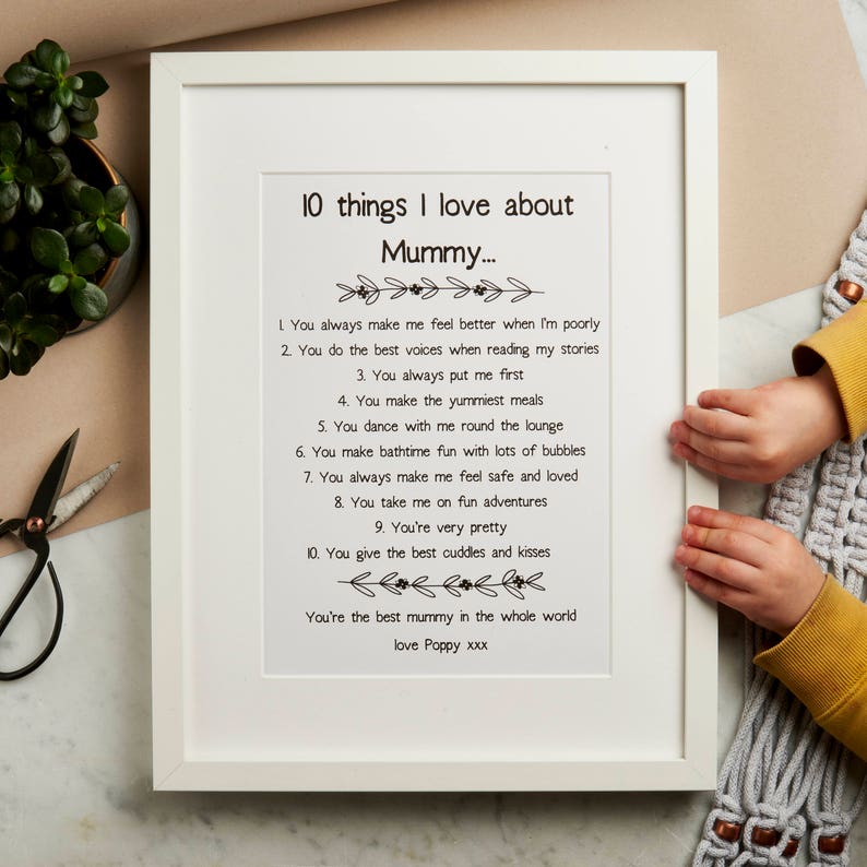 K&ouml;nnte beinhalten: Ein gerahmter Druck mit wei&szlig;em Hintergrund und schwarzem Text. Der Text lautet "10 Dinge, die ich an Mama liebe..." und listet 10 Gr&uuml;nde auf, warum jemand seine Mutter liebt. Der Druck ist mit "love Poppy xxx" signiert.