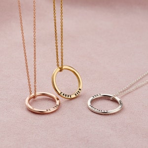 Puede incluir: Tres collares de oro con colgantes circulares. Los colgantes tienen diferentes palabras inscritas en ellos: "Be You", "Carpe Diem" y "Happiness is a Journey".