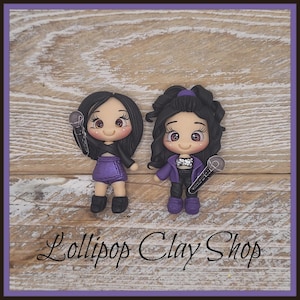 May include: Two clay figurines of female singers, each holding a microphone. One wears a purple skirt and black jacket, the other a purple jacket and black pants. The text "Lollipop Clay Shop" is at the bottom.