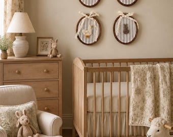 May include: Four circular embroidery hoops mounted on a wall, each containing grey and white striped fabric with a small, centered, three-dimensional animal figure and a decorative cream-colored lace bow tied at the top of each wooden frame.