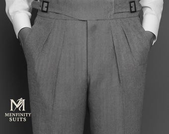 May include: Gray tailored trousers with a high waist and belt loops. The pants have pleats and pockets. The image also shows a white shirt and the logo "MENFINITY SUITS".
