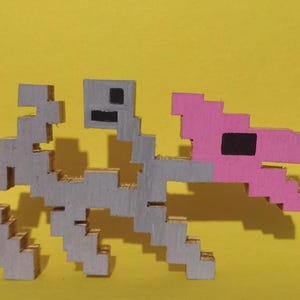 May include: A pixelated dinosaur skeleton sculpture with a gray body and a pink head. The dinosaur is set against a bright yellow background. The sculpture is made of cardboard and has a blocky, 8-bit style.