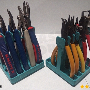 May include: Two teal tool organizers filled with various pliers. The pliers have red, blue, yellow, and tan handles. The handles have the word KNIPEX printed on them. The tools are arranged in a neat and organized manner.