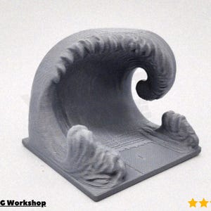 Pode incluir: Uma escultura de onda cinza impressa em 3D. A onda é retratada em uma forma dinâmica e encaracolada, com detalhes texturizados que sugerem a crista e o fluxo da água. A base é uma plataforma quadrada. O texto "@Triple C Workshop" é visível.