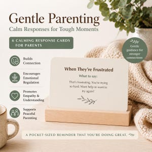 May include: A set of "Gentle Parenting" cards with "Calm Responses for Tough Moments" printed on them. The cards are displayed on a wooden stand. The text on the card reads "When They're Frustrated" and "That's frustrating. You're trying so hard."