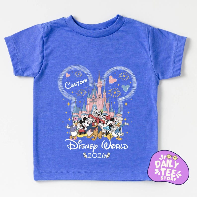 A blue t-shirt with a Disney World-themed graphic design, including Mickey Mouse, Donald Duck, and other Disney characters, along with a castle and fireworks. The text "Custom Disney World" and "Disney World 2026" is also visible.