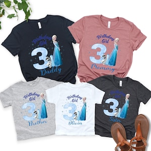a collection of birthday t-shirts featuring a character from the Disney movie Frozen, specifically Elsa. The t-shirts are designed for different age groups, with the largest one for a 3-year-old and the smallest one for a 3-year-old sibling. The t-shirts are arranged in a row, showcasing the variety of sizes and designs.
