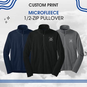May include: Three microfleece 1/2-zip pullovers in navy blue, black, and gray. Each pullover has a mock neck collar and a small logo on the chest. The image includes the text "CUSTOM PRINT MICROFLEECE 1/2-ZIP PULLOVER."