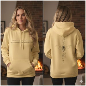 Peut inclure: Un sweat à capuche jaune clair avec une poche avant et une capuche à cordon. Le devant porte le texte : "Gracious words are honeycomb sweet to the soul, healing to the bones." Le dos présente un motif d'abeille.