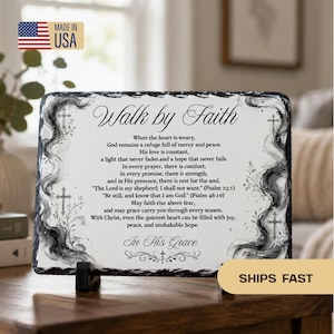 May include: A rectangular slate plaque with rough, chiseled edges featuring the black text Walk by Faith and a religious poem. The design includes black watercolor-style smoke patterns and small cross illustrations on the left and right sides.