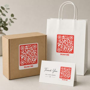 May include: A brown cardboard box, a white paper shopping bag, and a white thank you card, each featuring a red QR code sticker with the text SCAN ME. The card also includes the printed text Thank You FOR YOUR ORDER and a small heart.