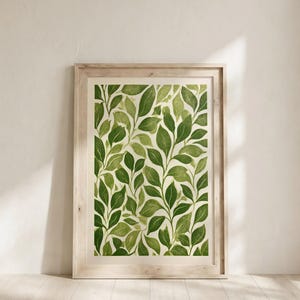 May include: A framed wall art print featuring a repeating pattern of green leaves on a cream background. The artwork is encased in a light-toned wooden frame with a rectangular shape, displaying a botanical illustration with various shades of green.