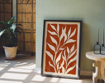 May include: A rectangular wall art print in a black frame featuring a bold terracotta orange background with a white, stylized botanical leaf pattern. The artwork is displayed vertically, showcasing a repeating organic foliage design.