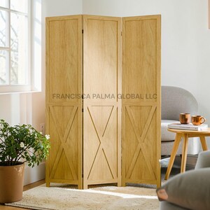 May include: A three-panel wooden room divider with an X-shaped design on each panel. The divider is made of light-colored wood and stands on a light-colored rug. The text "FRANCISCA PALMA GLOBAL LLC" is printed on the divider.