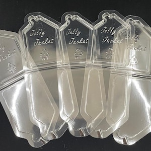 May include: Clear plastic "Jelly Jacket" packaging, featuring a house-shaped top with the text "Jelly Jacket" and a recycling symbol. The packaging is designed to hold a product, with a clear, transparent appearance.