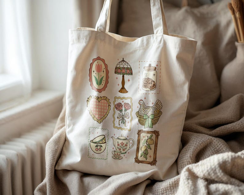 May include: Cream-colored tote bag featuring a collection of vintage-style illustrations. The designs include a tulip, a lamp, cookies in a jar, a heart, roses, a chicken in a basket, teacups, a teapot, and lemons. The bag has two handles.