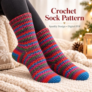 Pode incluir: Um par de meias feitas à mão em crochê com listras horizontais em tons vibrantes de vermelho, azul, verde e roxo com um brilho metálico sutil. O texto Crochet Sock Pattern, Sparkly Design, Digital PDF é visível.